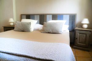 a bedroom with a large white bed with pillows at Logis Hôtel Restaurant Le Domaine de l'Eau Vive in Largentière +125 photos