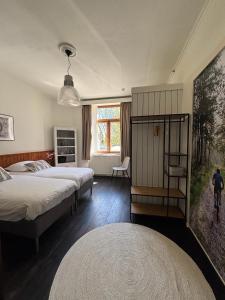 a bedroom with two beds and a large window at B&B Les Soigneurs in Grandmenil