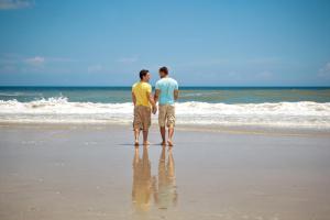 two men standing on the beach looking at the ocean at Relax & Sea in Ostend