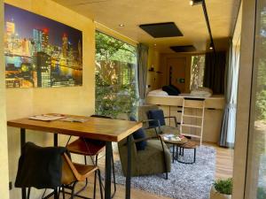 a room with a table and chairs and a bedroom at Skydeck Cabin met Jacuzzi & Rooftop in Holten