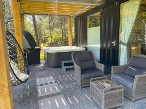 a screened in porch with two chairs and a tub at Skydeck Cabin met Jacuzzi & Rooftop in Holten