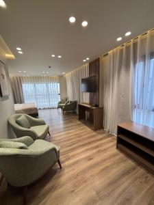 a living room with couches and a flat screen tv at Lake Plaza Luxury Rooms in Borg El Arab