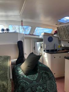 a living room with a couch and a kitchen in aurymarked at Passeio diurno e hospedagem de Veleiro Maverick in Paraty