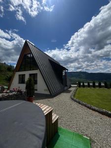 a small house with a gambrel roof on a driveway at A Dream Colibita in Colibiţa