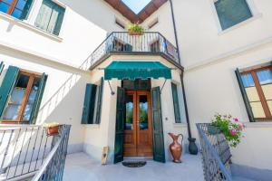 a house with a wooden door and a balcony at 108 B&B Valdobbiadene in Bigolino
