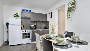 a kitchen with a dining table and a white refrigerator at Apartman Grey in Jastrebarsko