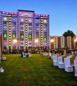 a large building with tables and chairs in front of it at Hotel Panigrahan in Bikaner