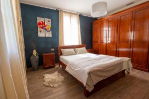 a bedroom with a bed and a wooden cabinet at 108 B&B Valdobbiadene in Bigolino