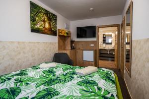 a bedroom with a bed with a green and white blanket at Vinný sklep u Křížů in Milotice +55 photos