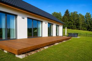 a wooden deck on the side of a house at Na kopečku u lesa in Březová