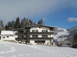 un edificio en la cima de una montaña cubierta de nieve en Landhaus Argus, en Fügenberg