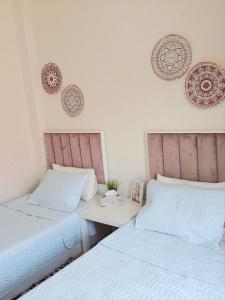 a bedroom with two beds and a table and plates on the wall at Villa in a compound with a rooftop in sheikh zayed in Sheikh Zayed