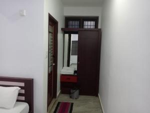 a room with a bed and a door with a mirror at Zero One Residency in Quilāndi