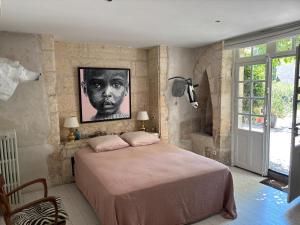 a bedroom with a bed and a portrait of a man at Le Bon Appart in Angoulême