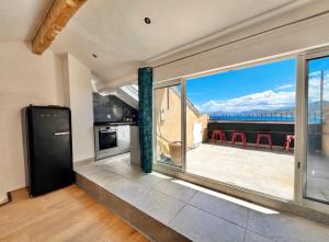 a kitchen with a large window with a view at Duplex sur la mer in LʼÎle-Rousse