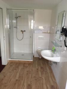 a bathroom with a shower and a sink and a toilet at tauwerk Hotel in Wilhelmshaven