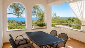 a dining room with a table and chairs and two windows at Ribarićevi dvori in Banjol