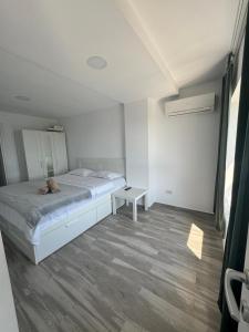 a white bedroom with a bed and a table at Olimp sea view in Olimp