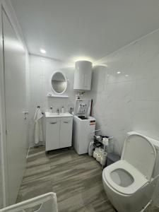 a white bathroom with a toilet and a sink at Olimp sea view in Olimp