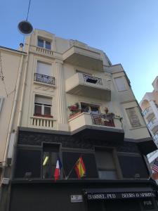 um edifício alto com duas varandas e bandeiras em Le Carré D'Or by Connexion em Cannes