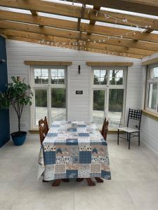 a patio with a table and chairs and windows at Mickeys Shed in Waterford