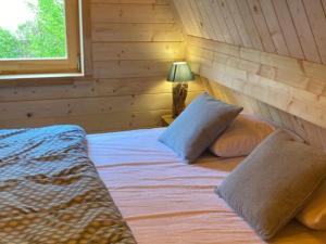 a bedroom with a bed with a wooden wall at Cabane spacieuse - 7 pers. - API-1-52-2440 in Meyrueis