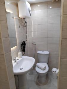 a bathroom with a white toilet and a sink at Papale AIRPORT HOUSE in CTA