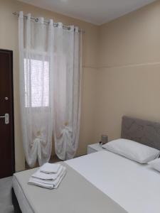 a bedroom with a bed and a window with white curtains at Papale AIRPORT HOUSE in CTA