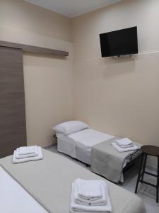 a hospital room with two beds and a flat screen tv at Papale AIRPORT HOUSE in CTA +3 photos