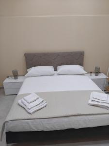 a white bed with two white towels on it at Papale AIRPORT HOUSE in CTA