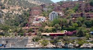 a group of houses on a hill next to the water at Club Patara Villas 222 in Kalkan