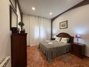 a bedroom with a bed and a dresser and a window at Alojamiento Rural Ambite in Ambite