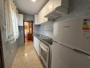 a kitchen with a refrigerator and a stove top oven at Alojamiento Rural Ambite in Ambite