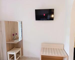 a room with a bench and a tv on the wall at Ever Green in Kavos