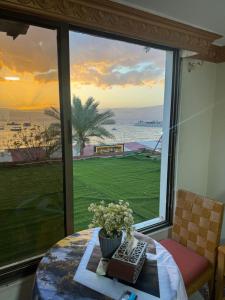 a room with a table and a view of the ocean at Al-Amer Aqaba Beach Hostel in Aqaba