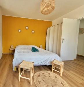 a bedroom with a bed and two stools in it at L'échappée Belle "15 min Europa Park" in Rhinau
