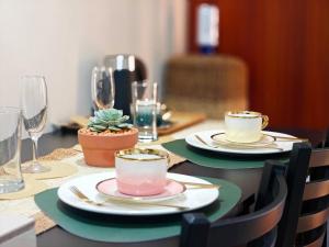 a table with plates and cups and glasses on it at WanderDesk Living-Studio Unit with Workstation in Piapi