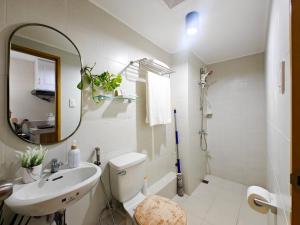 a bathroom with a sink and a toilet and a mirror at WanderDesk Living-Studio Unit with Workstation in Piapi