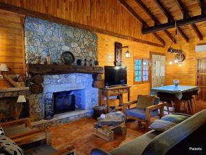 a living room with a stone fireplace and a table at Casa das Devesas in Caldelas
