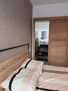 a bedroom with a bed with a wooden headboard at Voiron centre - De Tassigny in Voiron
