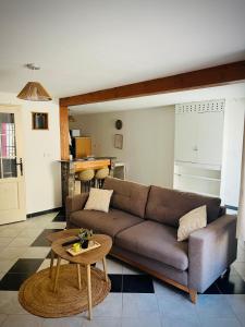 a living room with a brown couch and a table at Studio Cosy et Moderne in Saint-Ambroix