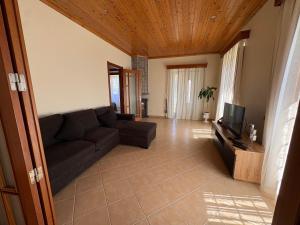 a living room with a couch and a television at Retiro da Ribeira in Angra do Heroísmo