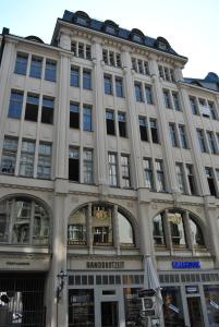 a large building with many windows on a street at Vailo City Suites Leipzig Altstadt in Leipzig