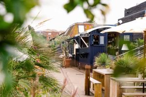 a blue bus parked next to a restaurant with plants at Rocksalt Rooms in Folkestone