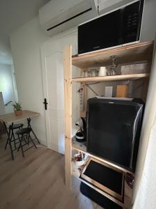 ein kleines Wohnzimmer mit Fernseher und Tisch in der Unterkunft Elo'Nco in Caderousse