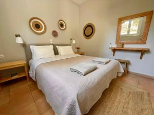a bedroom with a white bed with two towels on it at Myrtia Apartments in Divarata