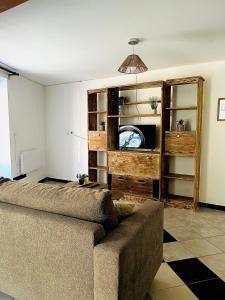 a living room with a couch and a tv at Studio Cosy et Moderne in Saint-Ambroix +2 photos