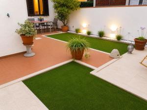 a courtyard with green grass and potted plants at La Casina di Perla in Viareggio