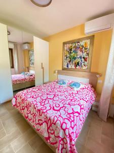 a bedroom with a bed with a pink bedspread at La Casina di Perla in Viareggio