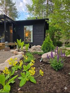 a garden with rocks and flowers in front of a house at Kataja Chalet with sauna and jacuzzi in Rovaniemi